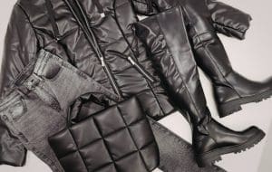 Femme portant une tenue de style équestre, veste matelassée et bottes en cuir