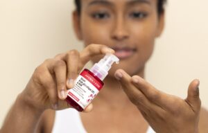 Flacon de sérum à l'acide glycolique posé sur une étagère de salle de bain