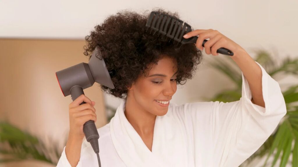 Diffuseur fixé sur l'extrémité d'un sèche-cheveux près de cheveux bouclés