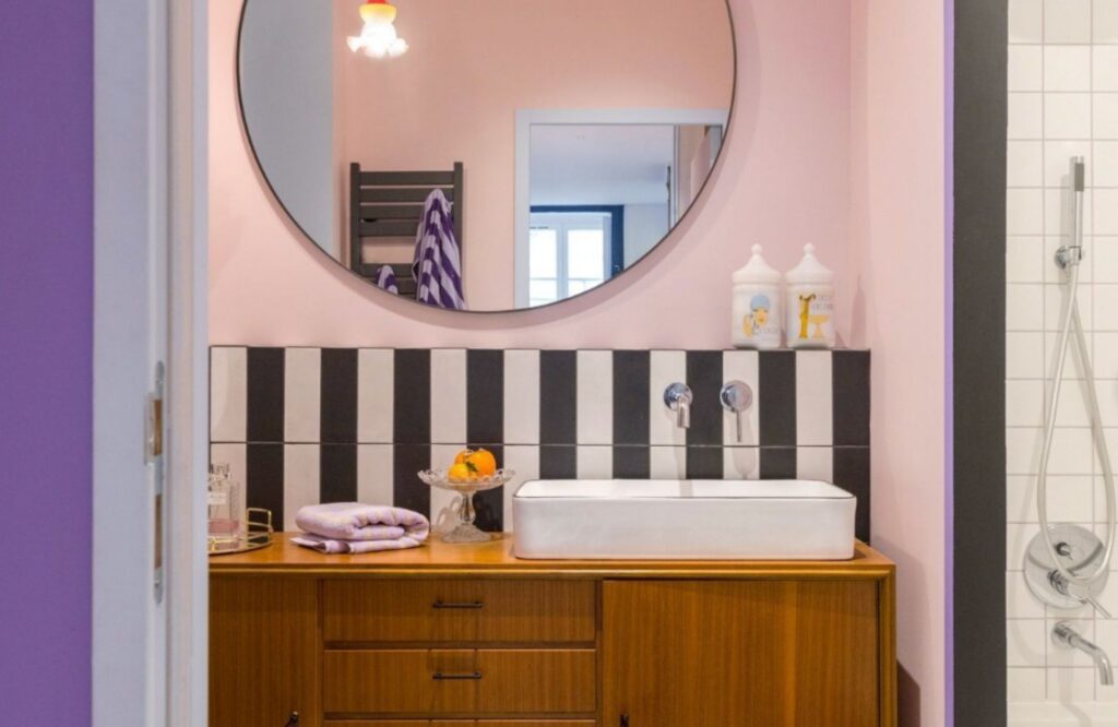 Salle de bain contemporaine aux murs vert sauge, bois clair et robinetterie dorée