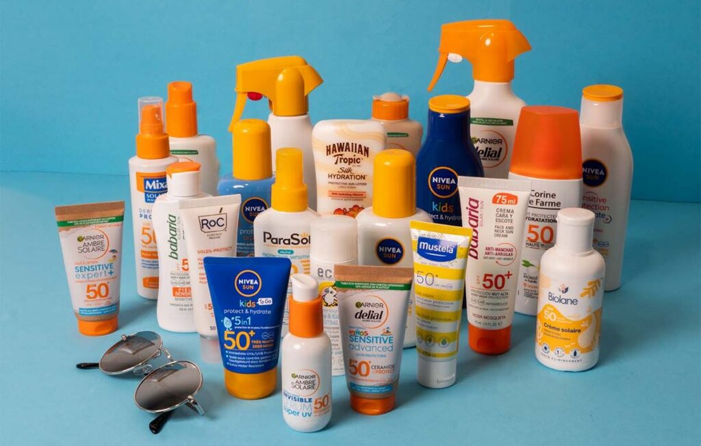 Tubes de crème solaire SPF 50+ recommandés par les dermatologues posés sur une serviette de plage
