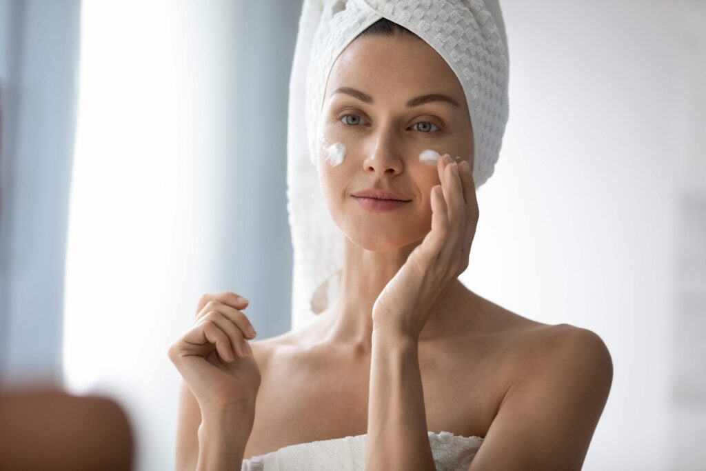 Femme appliquant une crème hydratante sur une peau sèche