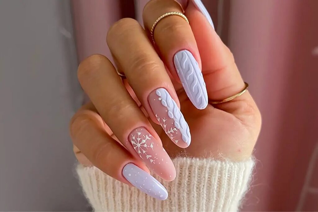Mains aux ongles amande vernis bordeaux profond posées sur un pull en maille crème